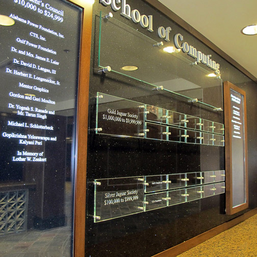 Sand carved & filled Starphire Glass, LED edge lit lasered panels in wood frames, Dimensional letters, brushed stainless hardware, Black Galaxy granite wall